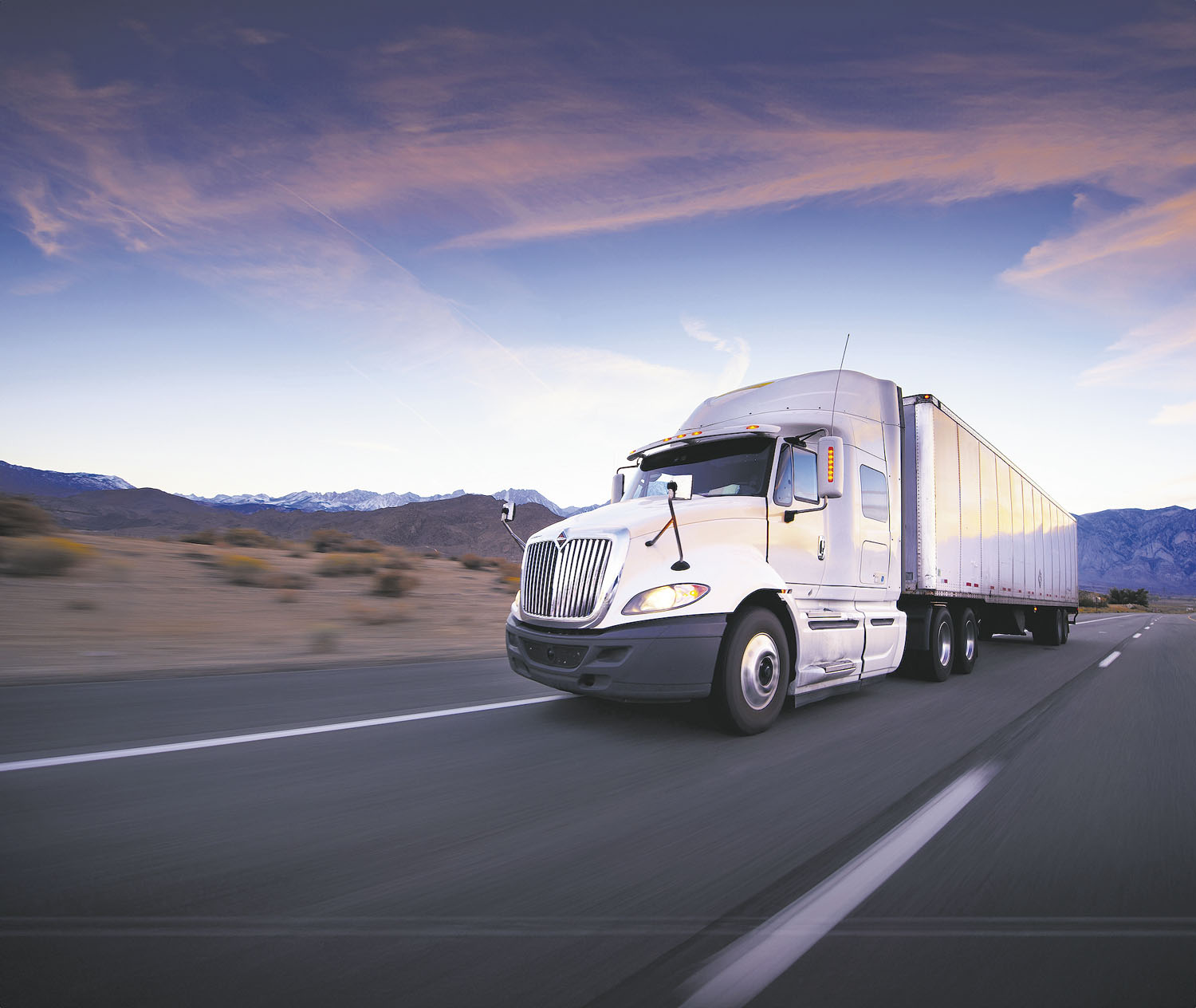 Truck and highway at sunset - transportation background
